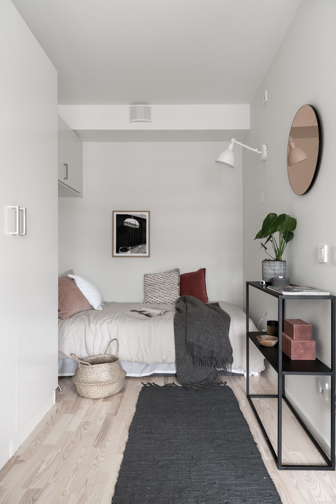 Inspiration for a small scandinavian master bedroom in Gothenburg with white walls, light hardwood floors and beige floor.