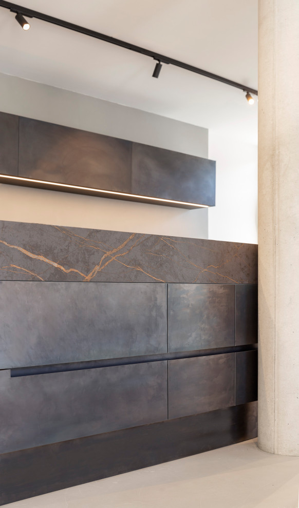 Esempio di una grande cucina minimalista con lavello integrato, ante lisce, ante nere, elettrodomestici in acciaio inossidabile, pavimento in cemento e top nero