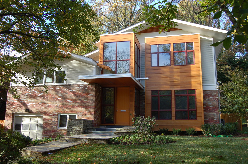 Photo of a mid-sized contemporary two-storey beige house exterior in DC Metro with a gable roof and mixed siding.