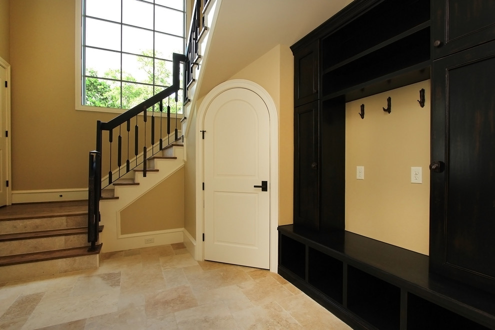 This is an example of an expansive transitional mudroom in Houston with travertine floors.