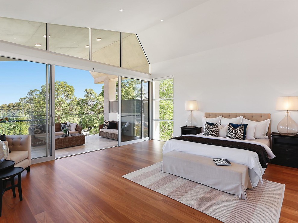 Photo of a transitional bedroom in Sydney with white walls, medium hardwood floors and no fireplace.