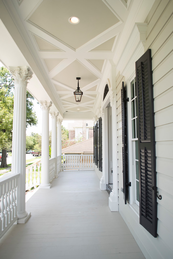 Expansive traditional front yard verandah in Houston with a roof extension and mixed railing.