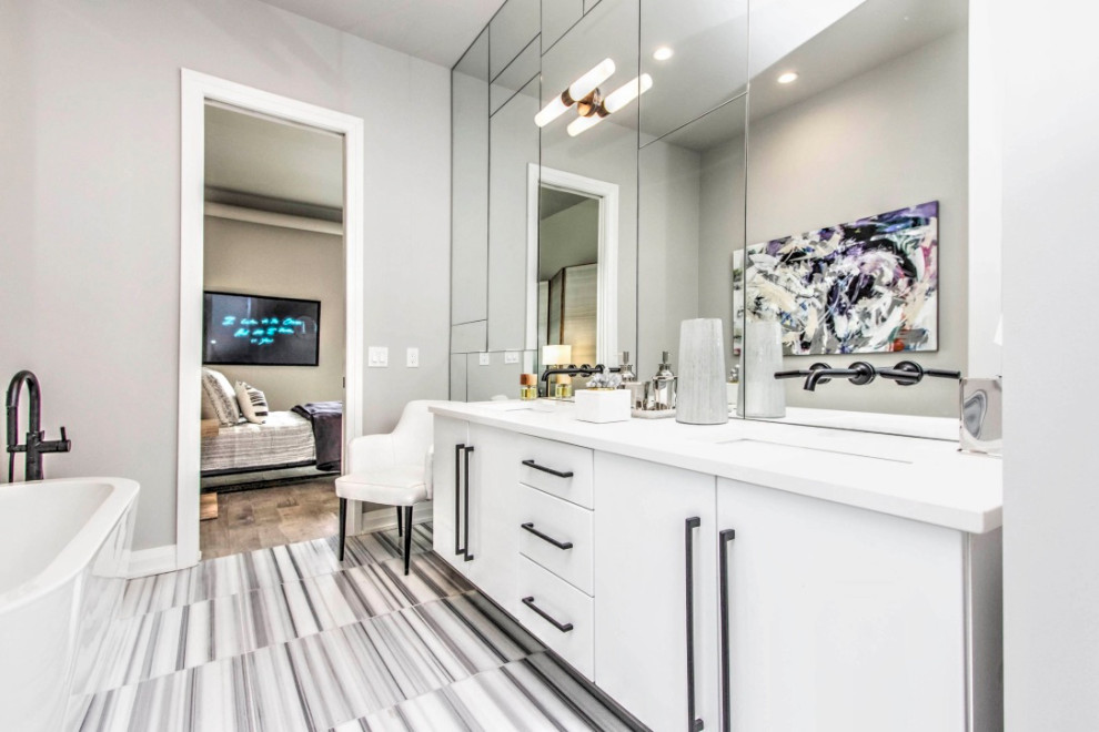 Inspiration for a large modern master bathroom in Minneapolis with flat-panel cabinets, white cabinets, a freestanding tub, an alcove shower, a one-piece toilet, multi-coloured tile, marble, grey walls, marble floors, an undermount sink, engineered quartz benchtops, multi-coloured floor, a hinged shower door and white benchtops.