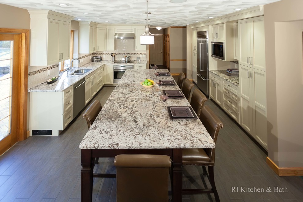 Transitional u-shaped eat-in kitchen photo in Providence with an undermount sink, shaker cabinets, beige cabinets, granite countertops, beige backsplash, subway tile backsplash and stainless steel appliances
