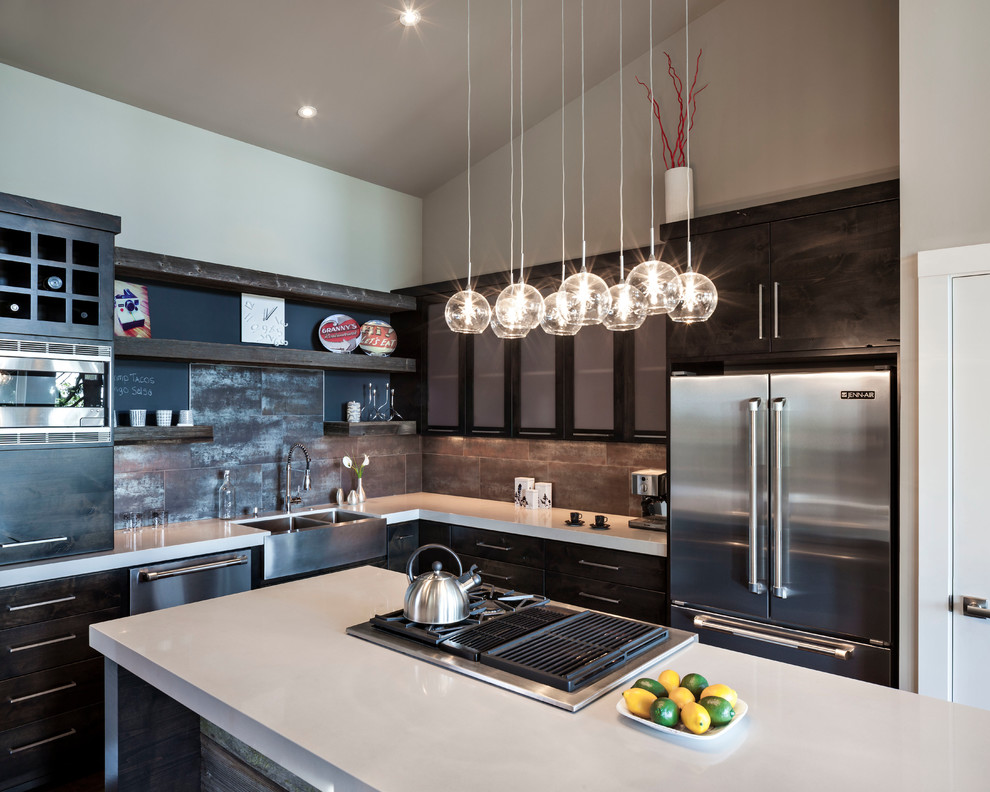 Enclosed kitchen - mid-sized industrial u-shaped enclosed kitchen idea in New York with a farmhouse sink, flat-panel cabinets, dark wood cabinets, granite countertops, brown backsplash, stone tile backsplash, stainless steel appliances and an island
