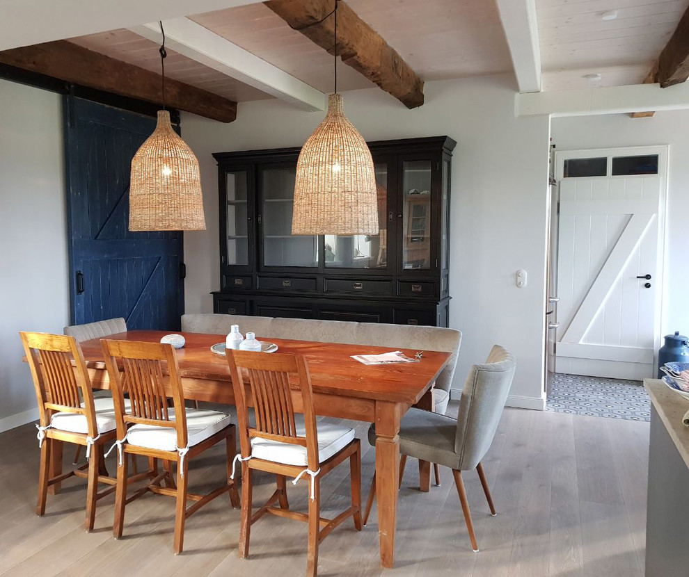Photo of a mid-sized country separate dining room in Hamburg with white walls, light hardwood floors, no fireplace and beige floor.