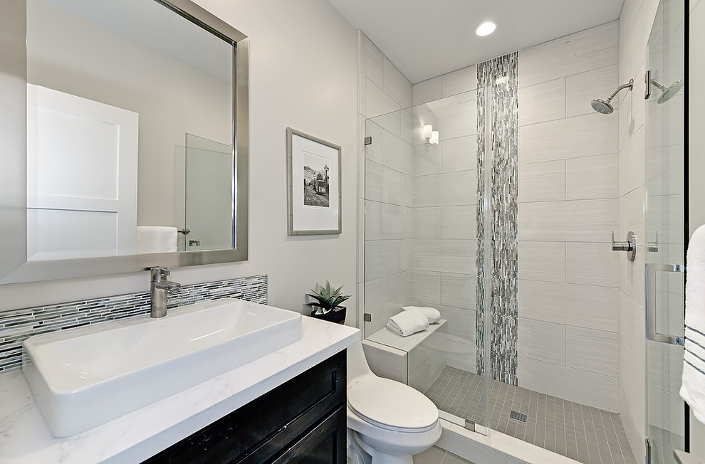 Photo of a transitional 3/4 bathroom in San Francisco with black cabinets, an alcove shower, grey walls, a vessel sink, recessed-panel cabinets, a one-piece toilet, marble benchtops, white tile, an open shower and white benchtops.