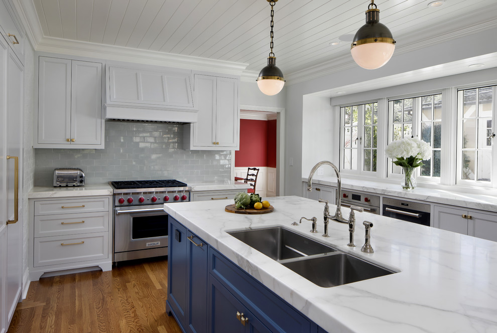 Inspiration for a transitional kitchen in San Francisco with a drop-in sink, shaker cabinets, blue cabinets, subway tile splashback, stainless steel appliances and medium hardwood floors.