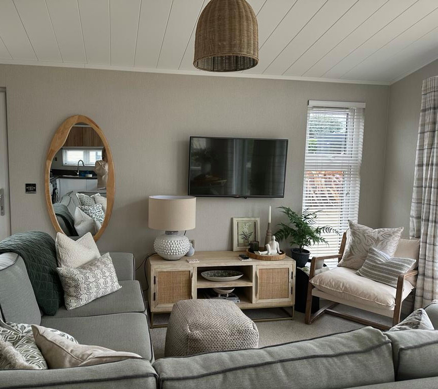 Small beach style grey and cream open plan living room in Other with beige walls, carpet, a wall mounted tv and grey floors.