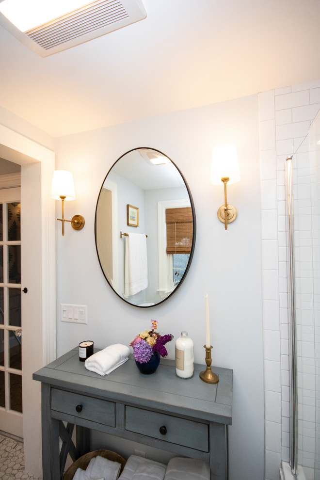 Mid-sized traditional master bathroom in Providence with recessed-panel cabinets, white cabinets, a drop-in tub, a shower/bathtub combo, a one-piece toilet, white tile, subway tile, blue walls, porcelain floors, an undermount sink, granite benchtops, white floor, a hinged shower door and white benchtops.