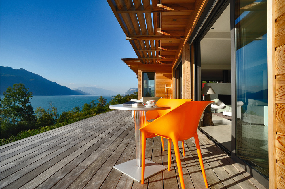 Inspiration for a mid-sized contemporary backyard deck in Grenoble with a roof extension.