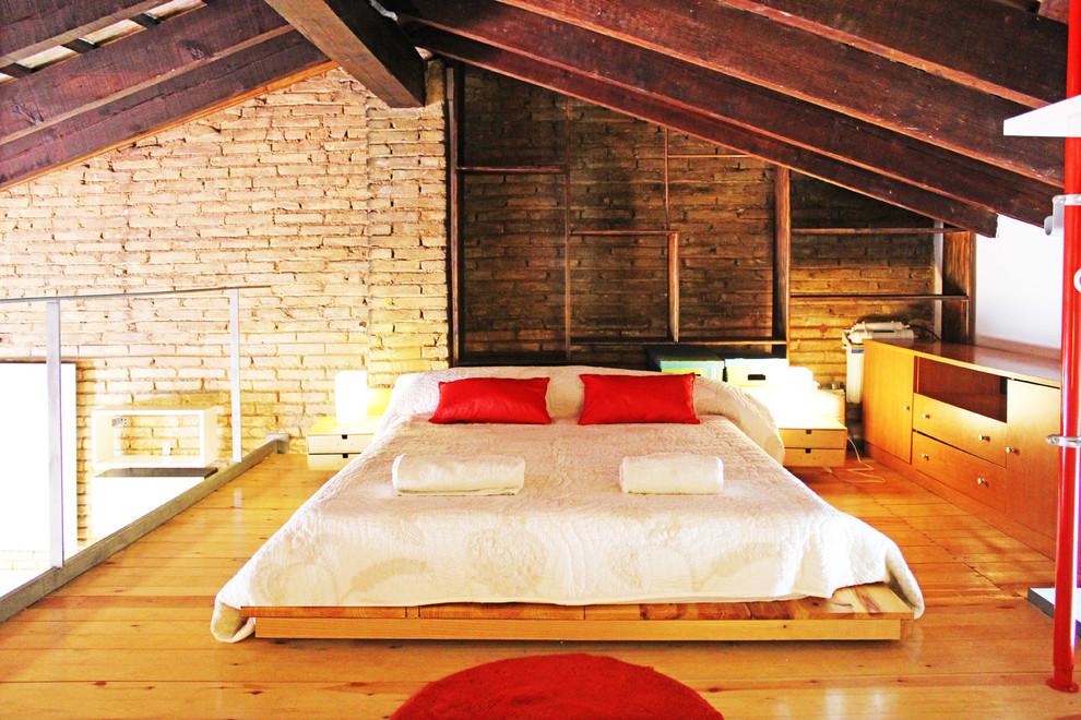 This is an example of a mid-sized industrial loft-style bedroom in Valencia.