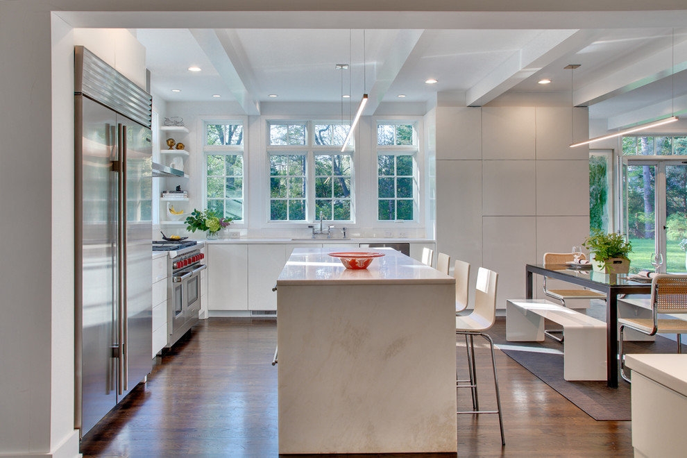Inspiration for a mid-sized contemporary l-shaped eat-in kitchen in New York with a single-bowl sink, flat-panel cabinets, quartzite benchtops, stainless steel appliances, dark hardwood floors, with island and white cabinets.
