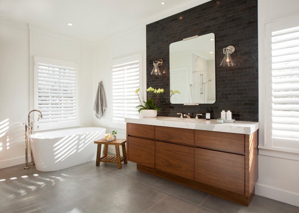 Mid-sized trendy master brown tile and subway tile gray floor and single-sink bathroom photo in New York with flat-panel cabinets, medium tone wood cabinets, white walls, an undermount sink, white countertops and a built-in vanity