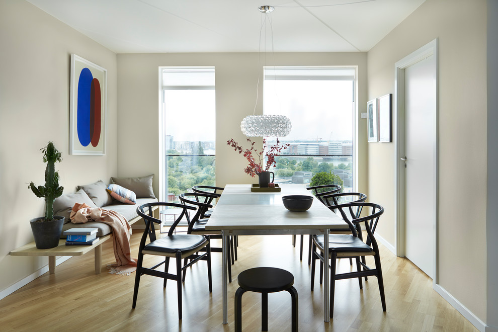 Design ideas for a mid-sized scandinavian dining room in Copenhagen with beige walls and light hardwood floors.