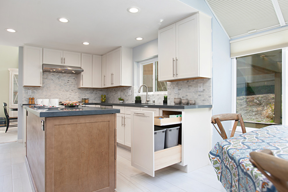 This is an example of a large traditional l-shaped eat-in kitchen in San Diego with an undermount sink, shaker cabinets, white cabinets, quartz benchtops, multi-coloured splashback, stone tile splashback, stainless steel appliances, porcelain floors, with island, grey floor and blue benchtop.
