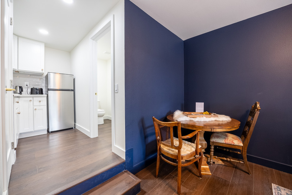 Foto di un piccolo angolo colazione tradizionale con pareti blu, pavimento in vinile, nessun camino, pavimento marrone e soffitto a volta