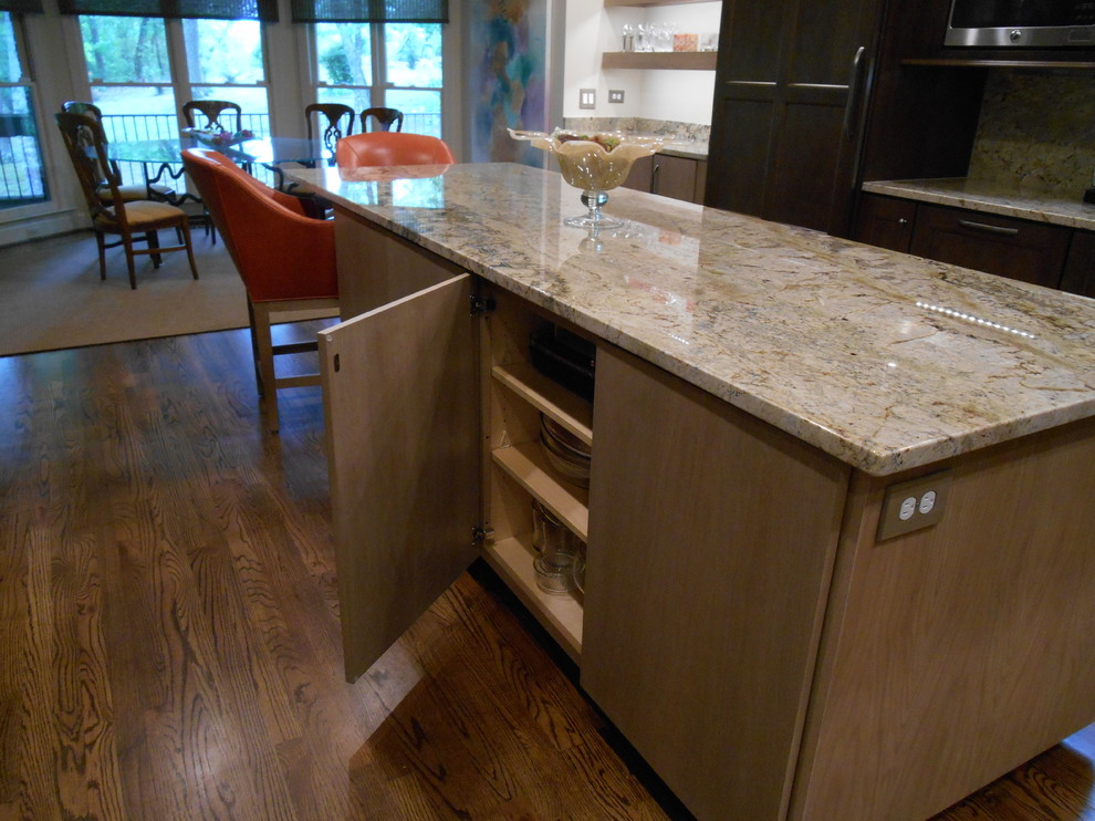 Inspiration for a mid-sized transitional l-shaped medium tone wood floor eat-in kitchen remodel in Birmingham with a single-bowl sink, flat-panel cabinets, medium tone wood cabinets, granite countertops, stone slab backsplash, paneled appliances, beige walls and an island
