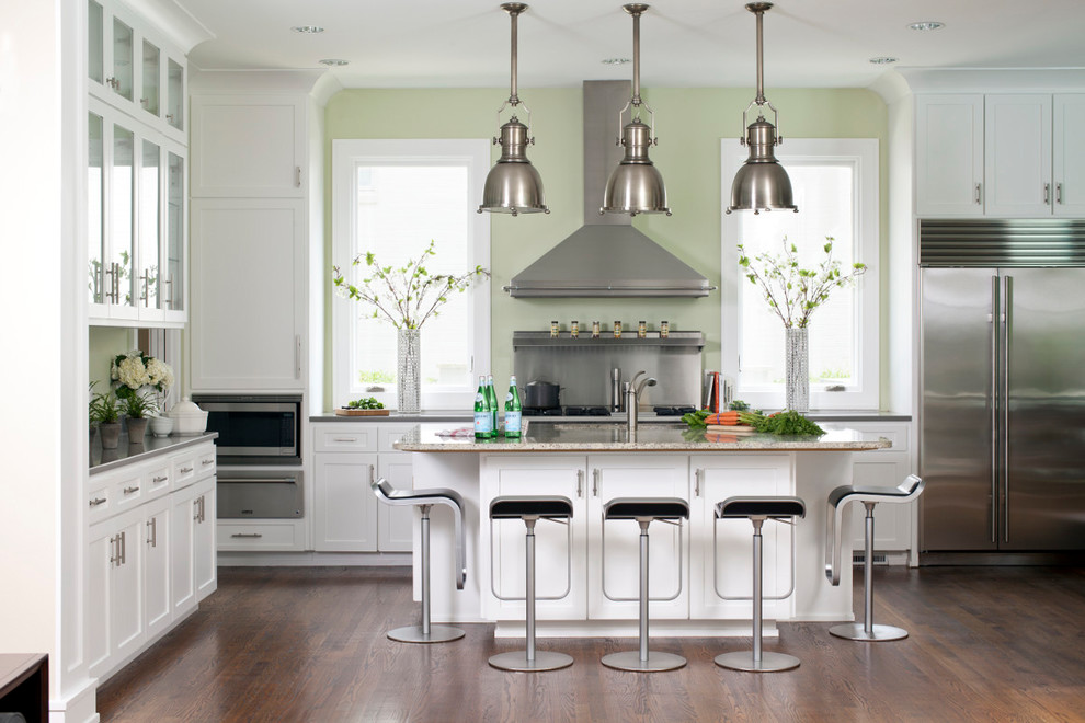 Inspiration for a transitional kitchen in Chicago with shaker cabinets, white cabinets, metallic splashback, stainless steel appliances, dark hardwood floors, with island and brown floor.