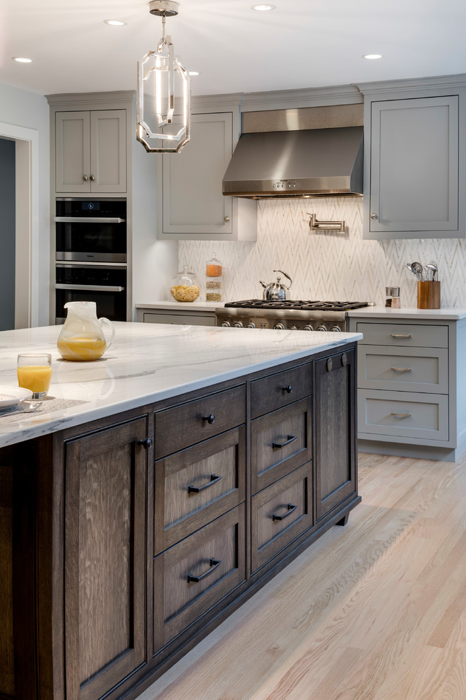 Inspiration for a large transitional l-shaped medium tone wood floor eat-in kitchen remodel in Boston with an undermount sink, flat-panel cabinets, gray cabinets, marble countertops and an island