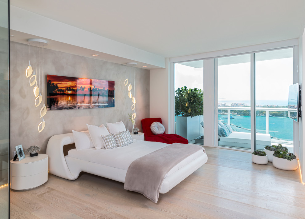 Inspiration for a mid-sized contemporary master bedroom in Miami with grey walls and light hardwood floors.
