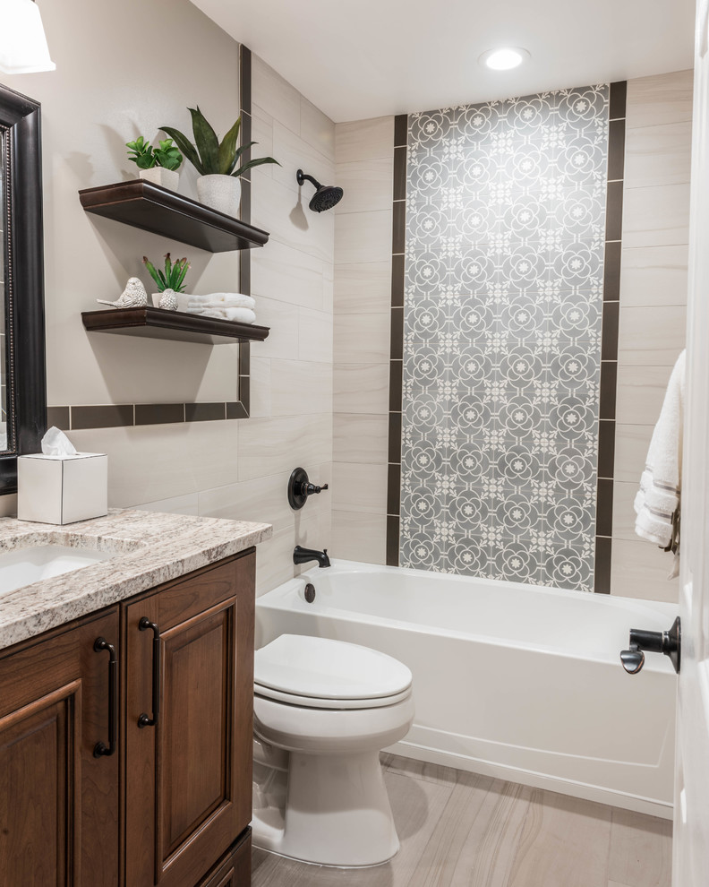 Design ideas for a mid-sized arts and crafts 3/4 bathroom in Other with raised-panel cabinets, medium wood cabinets, an alcove tub, a shower/bathtub combo, beige tile, porcelain tile, beige walls, porcelain floors, an undermount sink, granite benchtops and grey floor.