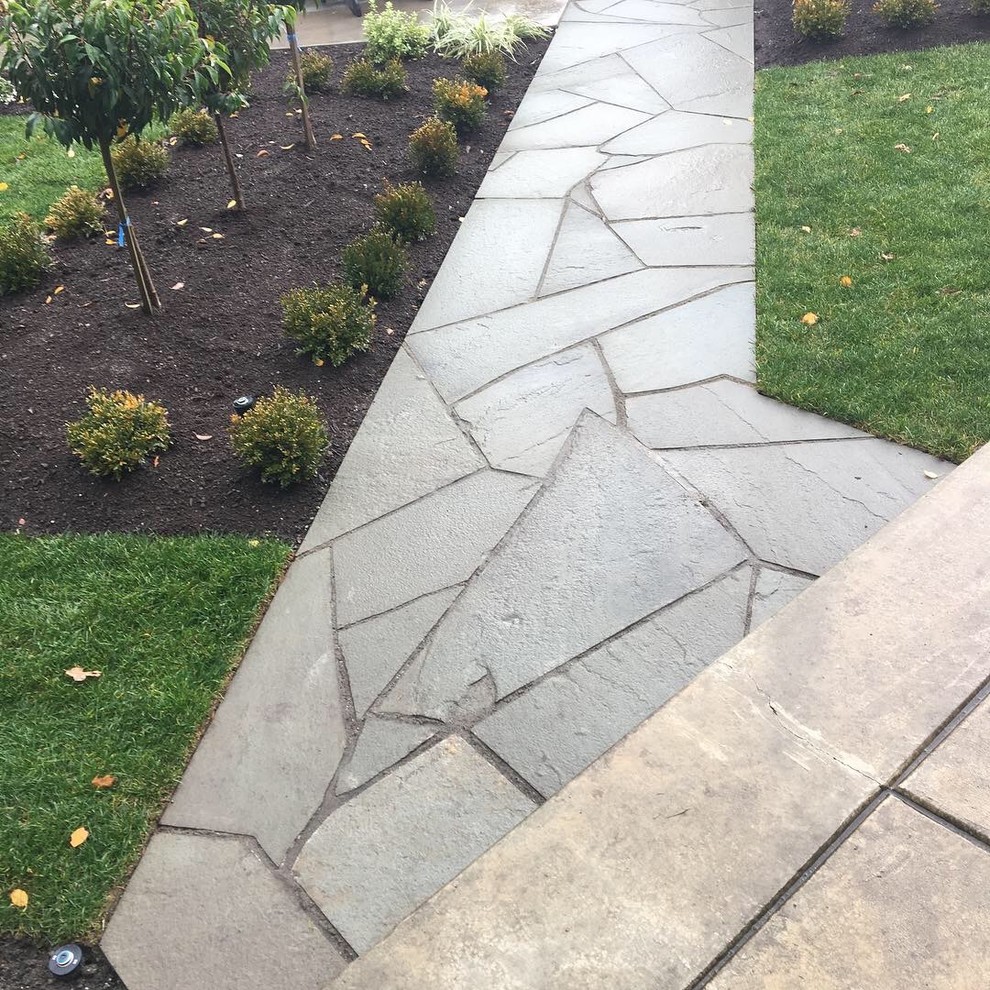 Inspiration for a mid-sized rustic full sun backyard stone landscaping.