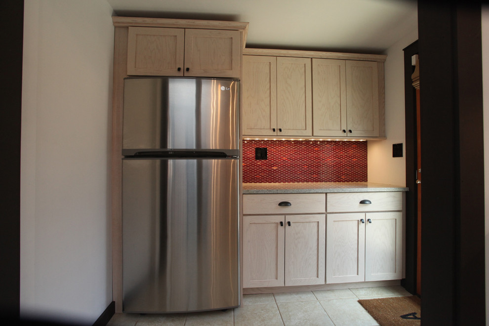 Inspiration for a transitional ceramic tile kitchen remodel in New York with an undermount sink, shaker cabinets, light wood cabinets, granite countertops, red backsplash, ceramic backsplash and stainless steel appliances