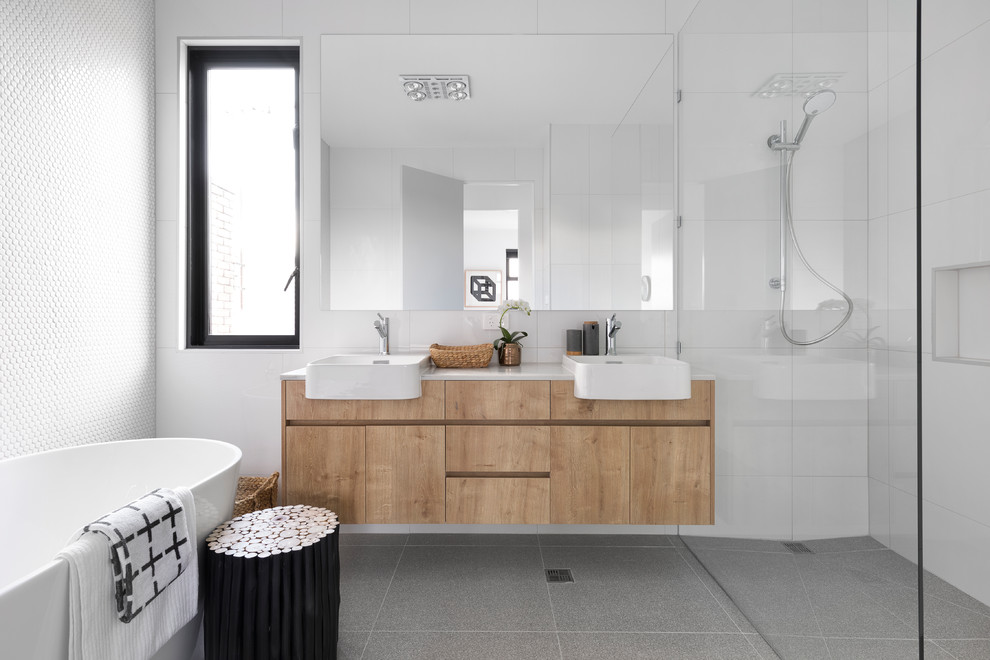 Inspiration for a contemporary master bathroom in Melbourne with flat-panel cabinets, light wood cabinets, a freestanding tub, a corner shower, white tile, mosaic tile, white walls, a vessel sink, grey floor, an open shower and beige benchtops.
