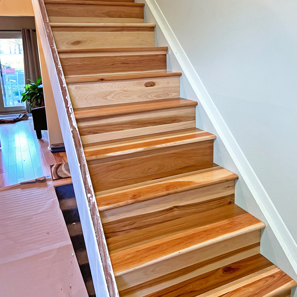 Imagen de escalera recta campestre de tamaño medio con escalones de madera, contrahuellas de madera y barandilla de madera