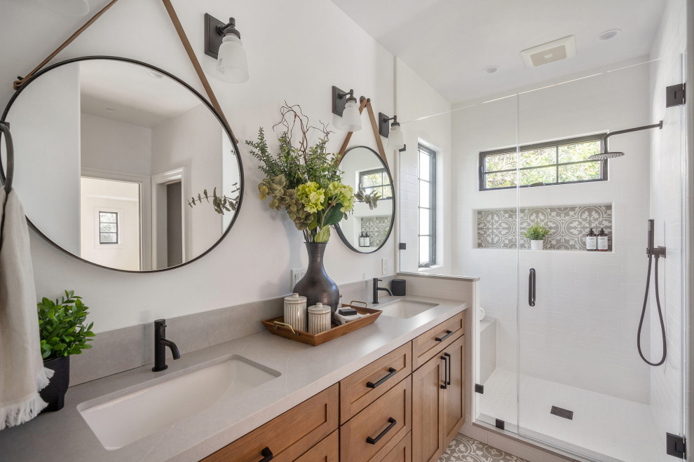 Photo of a mediterranean bathroom in San Francisco with an undermount tub, a shower/bathtub combo, a wall-mount toilet, white walls, ceramic floors, a niche and a built-in vanity.