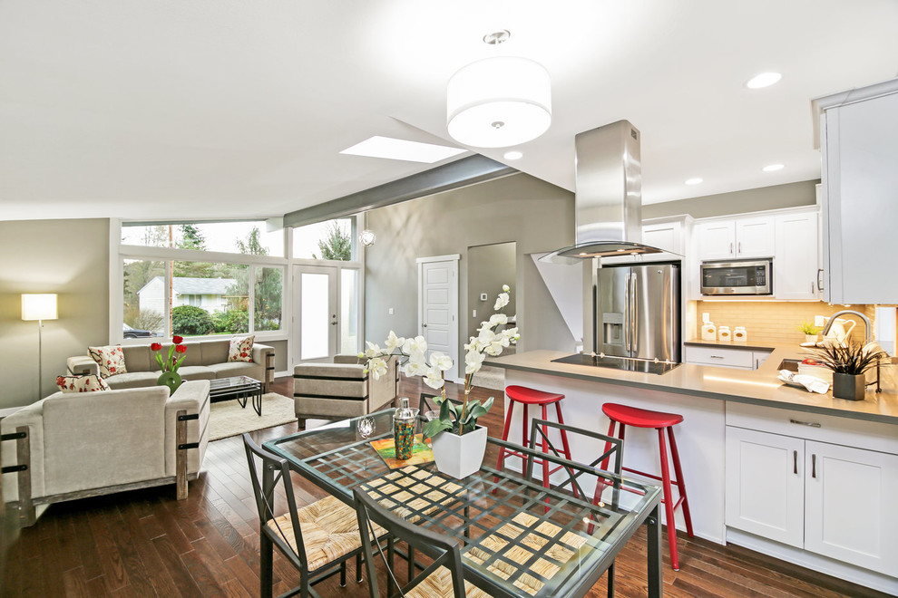 Eat-in kitchen - mid-sized transitional u-shaped medium tone wood floor and brown floor eat-in kitchen idea in Seattle with an undermount sink, shaker cabinets, white cabinets, quartz countertops, gray backsplash, glass tile backsplash, stainless steel appliances, a peninsula and gray countertops