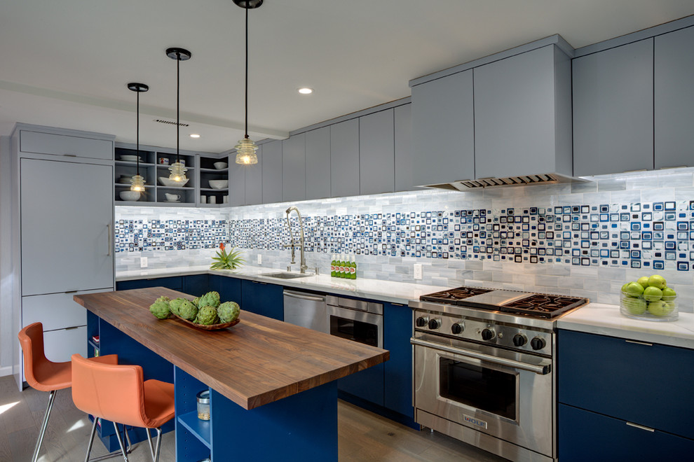 Design ideas for a mid-sized modern l-shaped eat-in kitchen in San Francisco with a single-bowl sink, flat-panel cabinets, blue cabinets, quartz benchtops, blue splashback, glass tile splashback, stainless steel appliances, medium hardwood floors, with island, brown floor and grey benchtop.