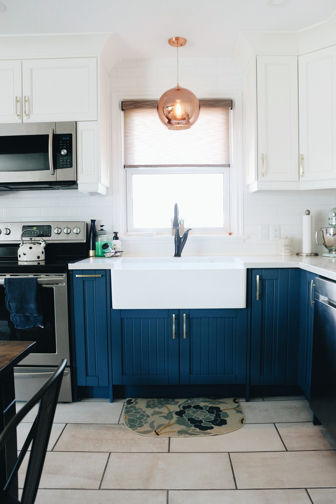 Mid-sized transitional u-shaped porcelain tile and multicolored floor eat-in kitchen photo in Toronto with a farmhouse sink, beaded inset cabinets, blue cabinets, quartzite countertops, white backsplash, ceramic backsplash, stainless steel appliances, no island and multicolored countertops