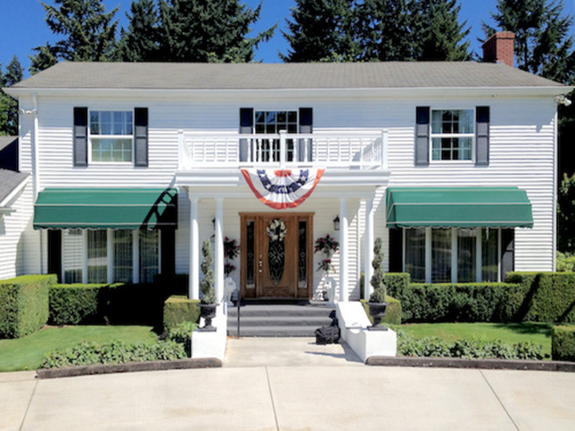 Example of a large classic white two-story vinyl house exterior design in Portland with a hip roof and a shingle roof