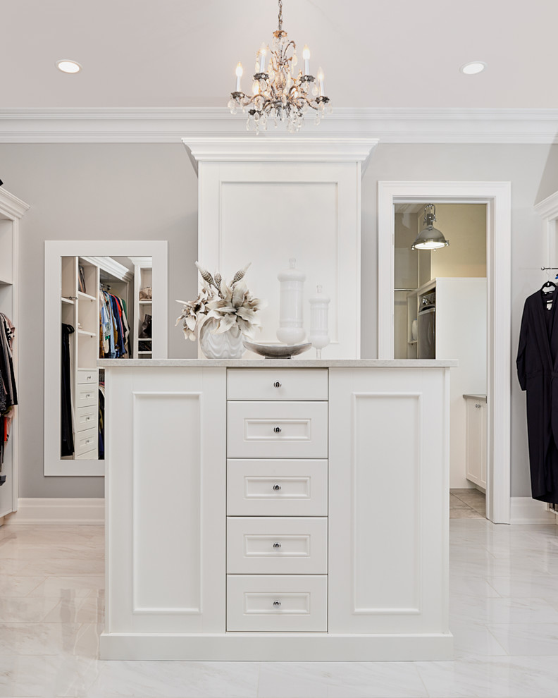 Photo of a large transitional gender-neutral walk-in wardrobe in Calgary with shaker cabinets and white cabinets.