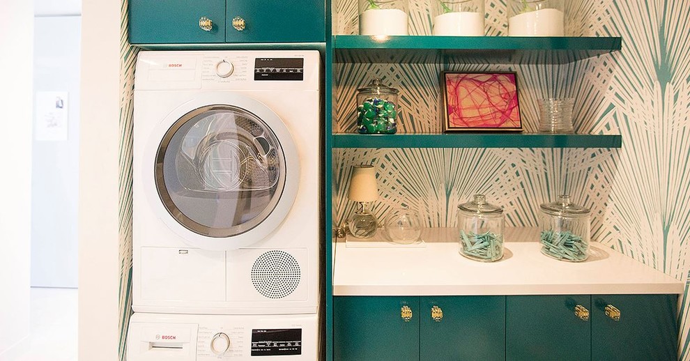 Photo of a small modern laundry room in Houston with flat-panel cabinets, multi-coloured walls, a stacked washer and dryer and blue cabinets.