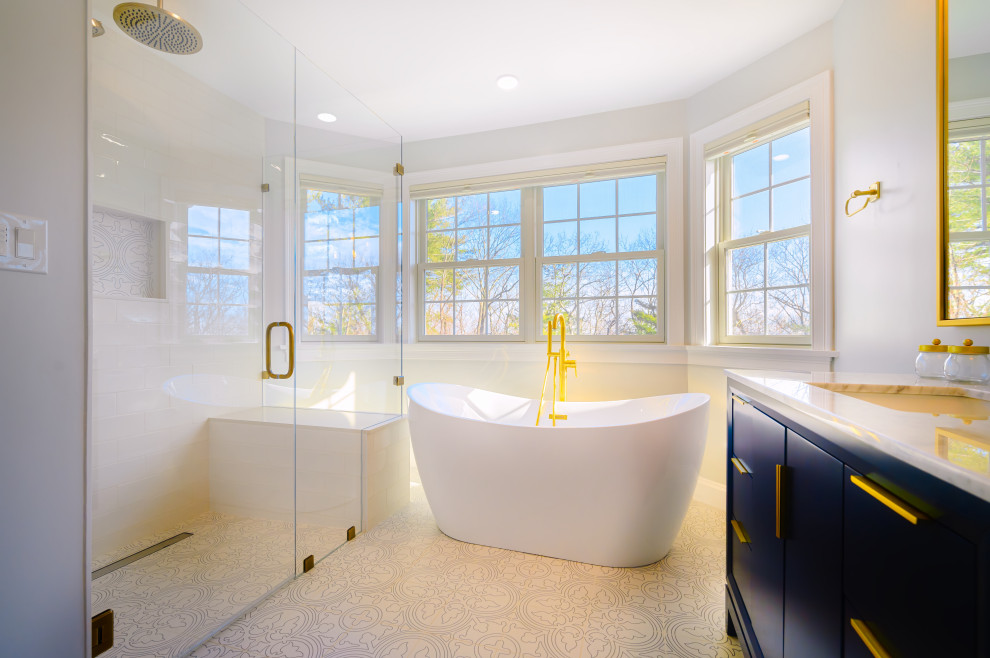 Large transitional master bathroom in Boston with flat-panel cabinets, blue cabinets, a shower/bathtub combo, a one-piece toilet, beige tile, white walls, ceramic floors, a drop-in sink, quartzite benchtops, beige floor, a hinged shower door, white benchtops, a single vanity and a freestanding vanity.