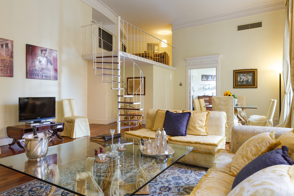 This is an example of a large eclectic open concept family room in Rome with yellow walls and dark hardwood floors.