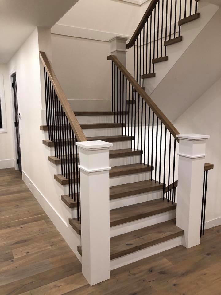 Photo of a large transitional wood u-shaped staircase in Vancouver with painted wood risers and mixed railing.