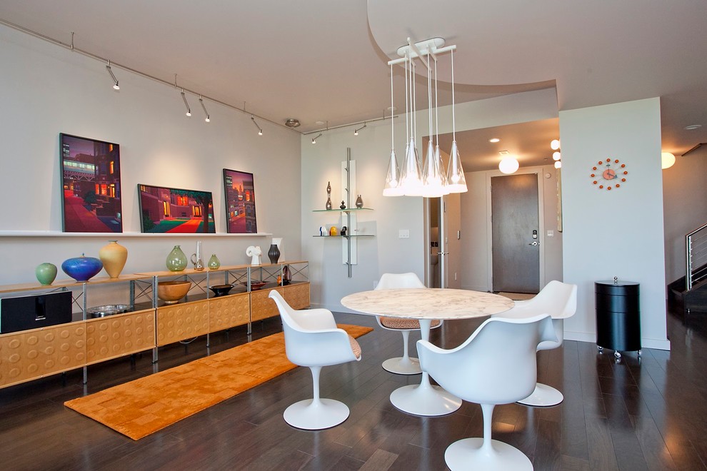 Inspiration for a modern kitchen/dining combo in Raleigh with white walls and dark hardwood floors.