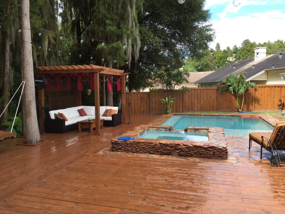 Mid-sized tropical backyard rectangular pool in Tampa with a hot tub and decking.