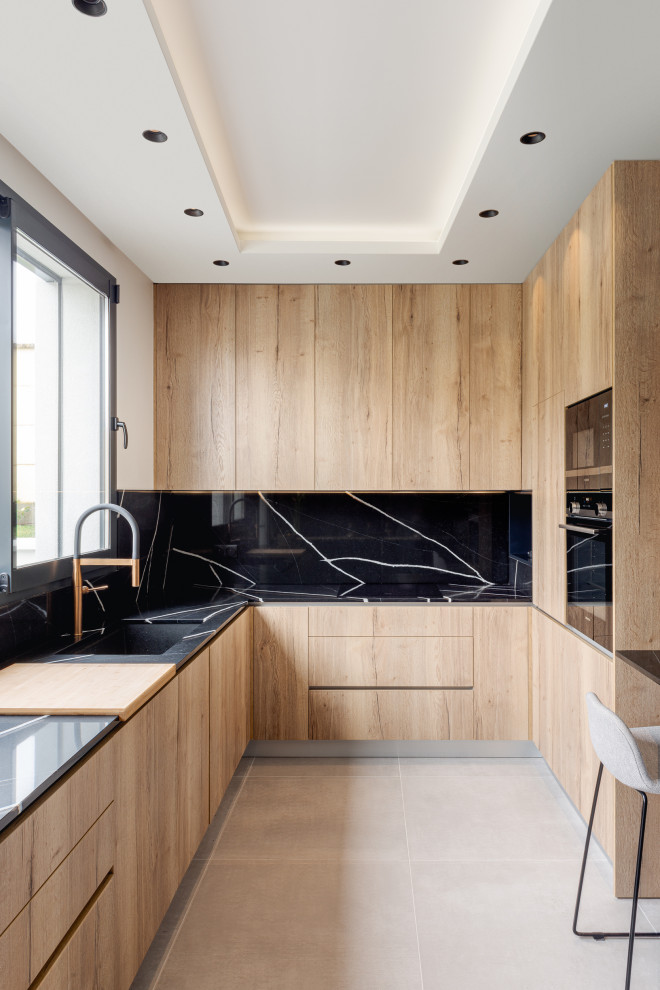 Photo of a large contemporary u-shaped open plan kitchen in Paris with a submerged sink, flat-panel cabinets, black cabinets, wood worktops, black splashback, marble splashback, black appliances, ceramic flooring, a breakfast bar, grey floors and beige worktops.