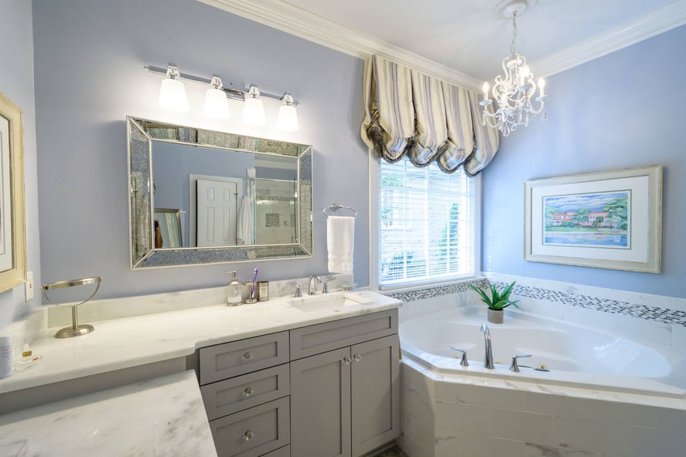 Large traditional master bathroom in Raleigh with shaker cabinets, grey cabinets, a drop-in tub, a corner shower, a two-piece toilet, blue walls, an undermount sink, quartzite benchtops and a hinged shower door.