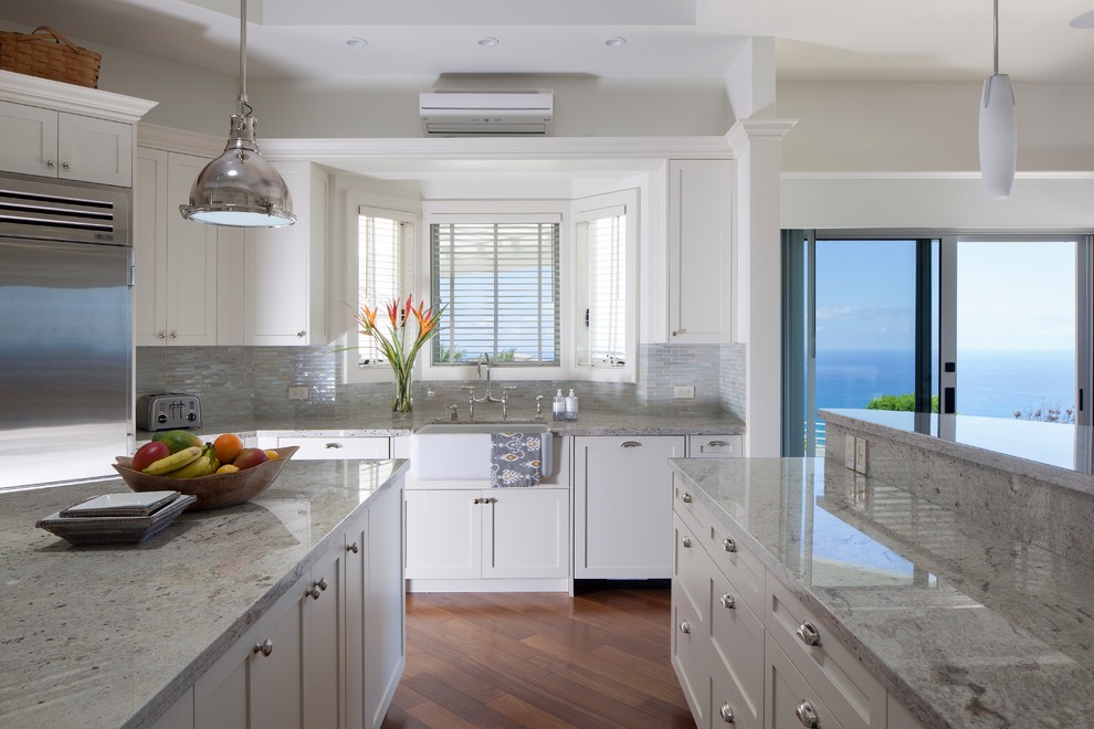 Design ideas for a tropical kitchen in Hawaii with a farmhouse sink, shaker cabinets, white cabinets, stainless steel appliances and granite benchtops.