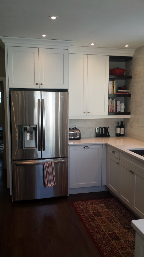 Inspiration for a mid-sized transitional u-shaped dark wood floor enclosed kitchen remodel in Ottawa with an undermount sink, shaker cabinets, white cabinets, quartz countertops, white backsplash, subway tile backsplash, stainless steel appliances and a peninsula