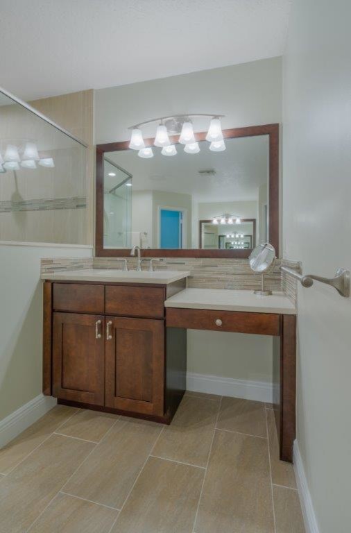 Example of a transitional beige tile and porcelain tile porcelain tile home design design in Miami with shaker cabinets, medium tone wood cabinets, a two-piece toilet, an undermount sink and quartz countertops