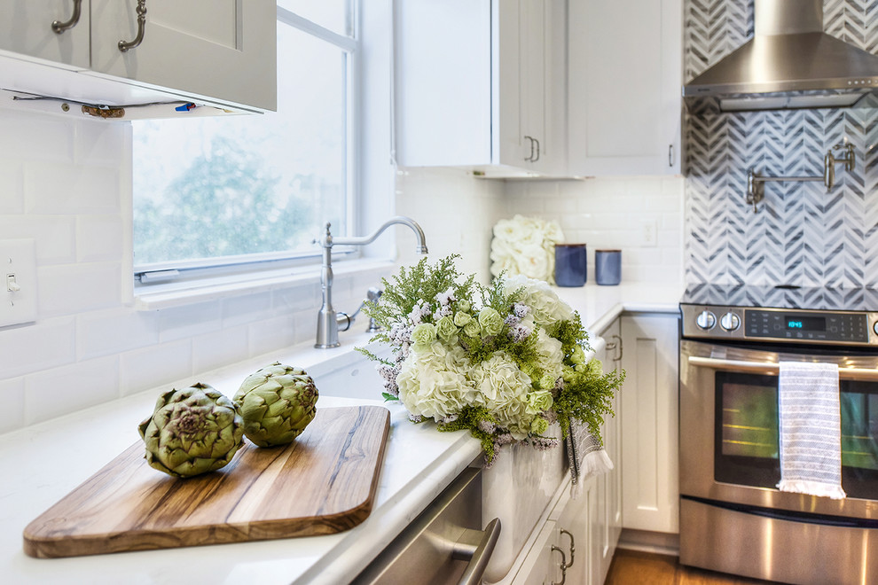 Example of a large transitional l-shaped medium tone wood floor eat-in kitchen design in Jacksonville with a farmhouse sink, shaker cabinets, quartz countertops and an island