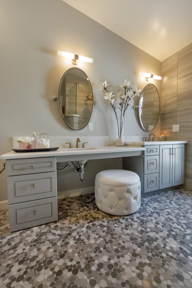 This is an example of a mid-sized transitional master bathroom in Phoenix with raised-panel cabinets, grey cabinets, an open shower, a one-piece toilet, gray tile, porcelain tile, grey walls, pebble tile floors, a drop-in sink, quartzite benchtops, grey floor and an open shower.