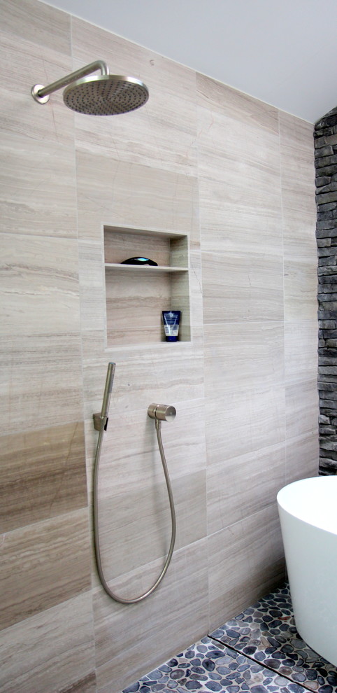Photo of a mid-sized contemporary master bathroom in Atlanta with a curbless shower, gray tile, flat-panel cabinets, grey cabinets, a freestanding tub, a two-piece toilet, stone tile, white walls, limestone floors, a vessel sink, granite benchtops, grey floor, an open shower, black benchtops, a niche, a double vanity, a floating vanity and vaulted.